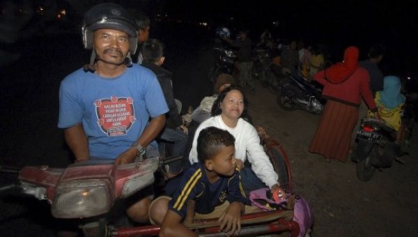 Residents leave their homes for higher land, after an earthquake hit the west coast of Sumatra, in Padang.