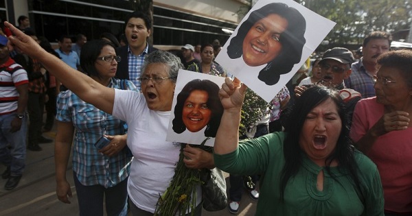 Activists hold photos of slain environmental rights activist Berta Caceres and shout after her body was released from the morgue in Tegucigalpa, March 3, 2016.