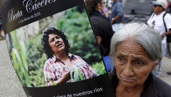 A woman holds up a poster with an image of Berta Caceres along a street during her funeral in the town of La Esperanza, Honduras, March 5, 2016.