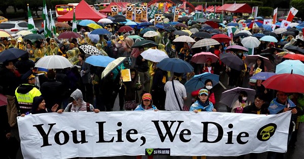 Taiwanese holding placards take part in the annual anti-nuclear protest during a downpour in Taipei, Taiwan.