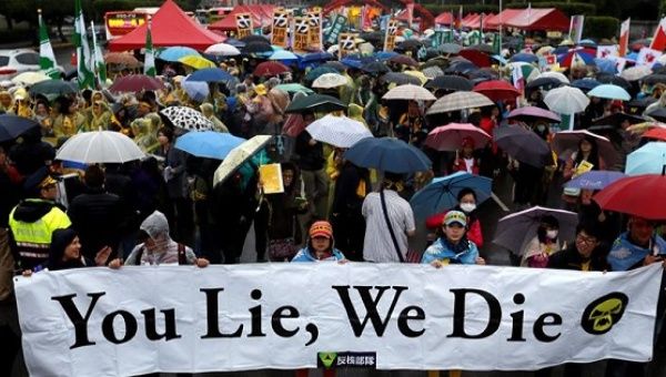 Taiwanese holding placards take part in the annual anti-nuclear protest during a downpour in Taipei, Taiwan.