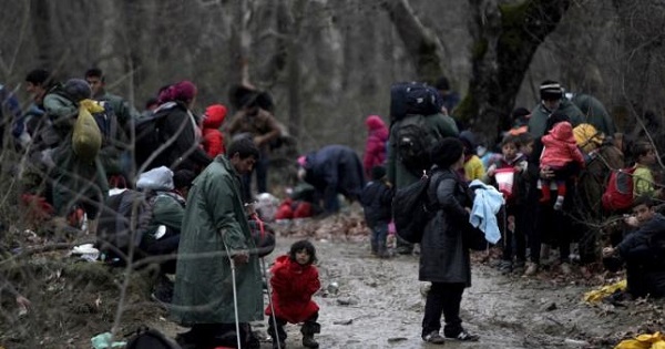 Migrants walk through a forest as they look for a way to cross the Greek-Macedonian border, near the village of Idomeni, Greece, March 14, 2016.