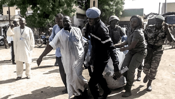 Security forces transport with a blanket the remains of some of the eleven victims of a double blast in the northern Cameroonian city of Maroua on July 22, 2015, after two girls blew themselves up in twin attacks.