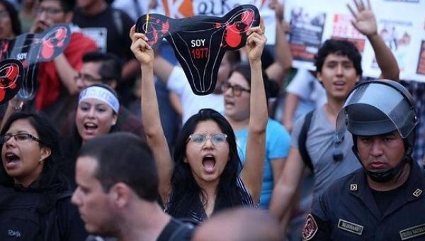 A demonstrator holds up a uterus protest sign representing victims of forced sterilization under Alberto Fujimori during a protest against Keiko Fujimori in Lima, Peru, March 11, 2016.