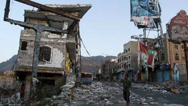 Man walks past a building destroyed during recent fighting in Yemen's southwestern city of Taiz.