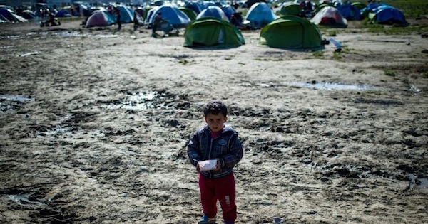 A boy stands in a field at a makeshift migrant camp at the Greek-Macedonian border near the village of Idomeni, on March 25, 2016