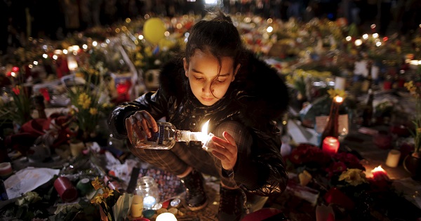 A girl lights candles as people pay tribute to the victims of Tuesday's bomb attacks, at the Place de la Bourse in Brussels, Belgium, March 26, 2016.