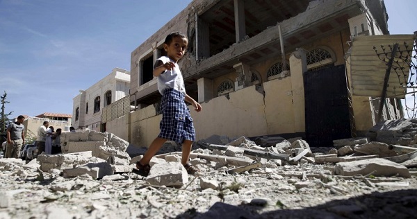 A boy walks past the a house damaged by a Saudi-led air strike in Yemen's capital Sanaa.