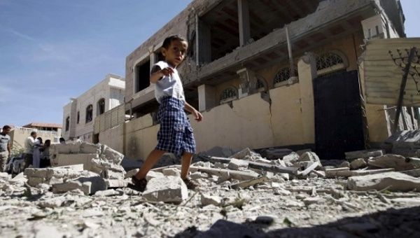 A boy walks past the a house damaged by a Saudi-led air strike in Yemen's capital Sanaa.