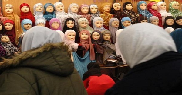 Women look at headgear of Muslim women during the 27th annual meeting of French Muslims in Paris, April 3, 2010.