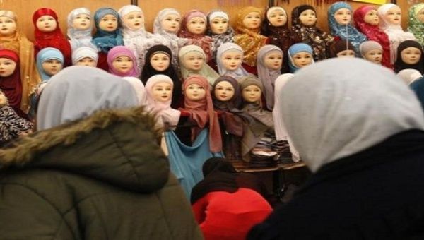 Women look at headgear of Muslim women during the 27th annual meeting of French Muslims in Paris, April 3, 2010.