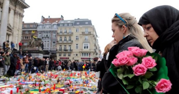 People observe a minutes silence at a street memorial to victims of the bombings in Brussels, Belgium, March 24, 2016