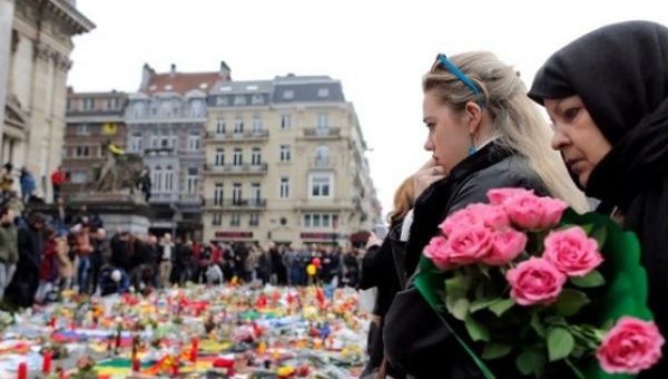 People observe a minutes silence at a street memorial to victims of the bombings in Brussels, Belgium, March 24, 2016