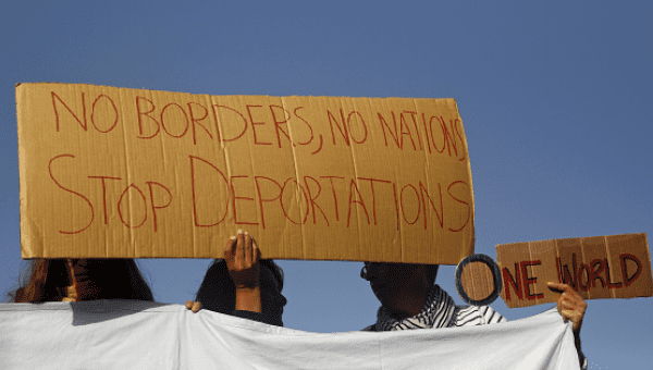 Activists hold placards as they protest against the return of migrants to Turkey, at the port of Mytilene on the Greek island of Lesbos, April 4, 2016.