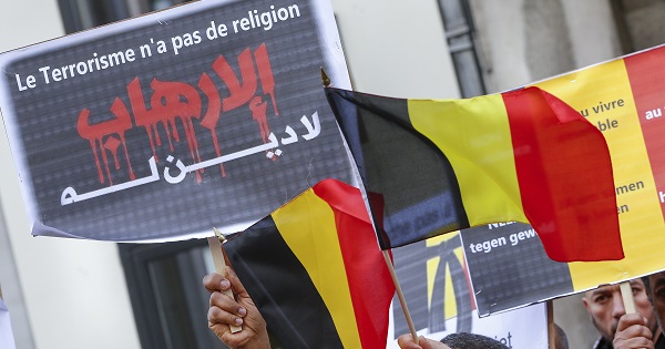 Members of the Muslim community in Belgium hold posters and flags during a ceremony for victims of last month's attacks in Brussels, Belgium, April 9, 2016.