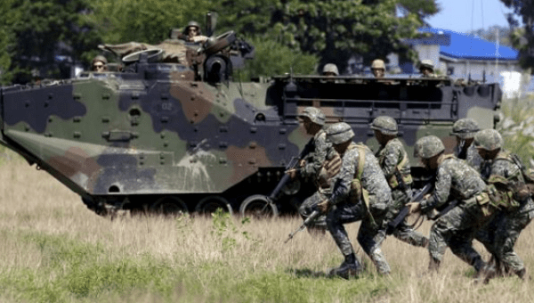 U.S. soldiers aboard an amphibious armoured vehicle watch as Philippine marine troops run during assault exercises in joint drills aimed at enhancing cooperation between the allies at a Philippine Naval base San Antonio, Zambales Oct. 9, 2015.