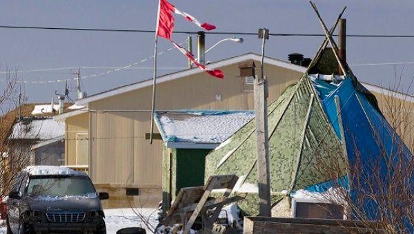 A tattered Canadian flag flies over a teepee in Attawapiskat, Ontario, in this file photo taken December 17, 2011. 