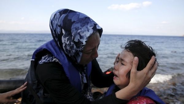 An Afghan mother comforts her crying child moments after a dinghy carrying Afghan migrants arrived on the island of Lesbos, Greece August 23, 2015.