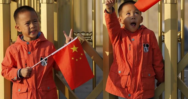 Twin boys Sun Qiyu and Sun Qichun hold China's national flags on the Tiananmen Gate in Beijing Nov. 2, 2015.