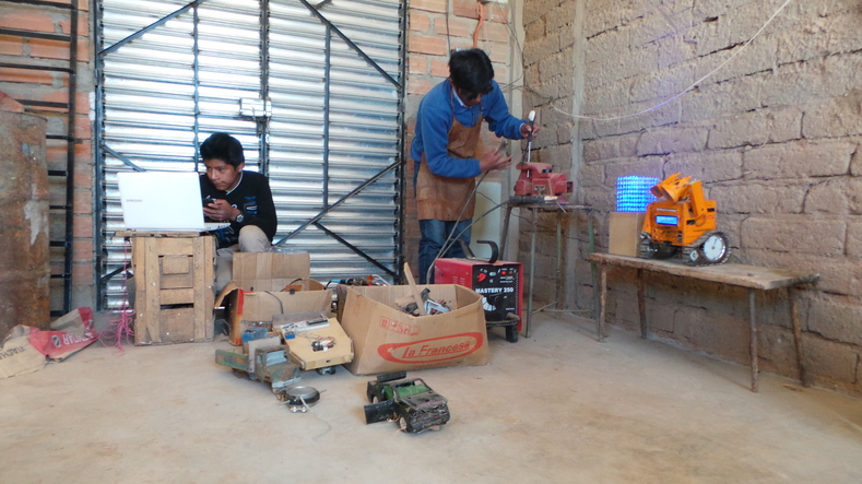 Esteban and Hernan are busy inventing new robots together in their workshop.