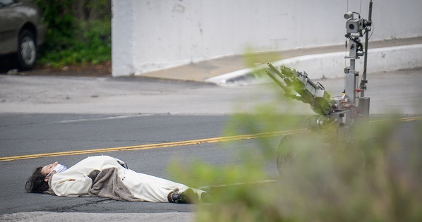 A man, claiming to have a bomb, lays in the street outside of the Fox45 television station in Baltimore, which was evacuated due to a bomb threat.