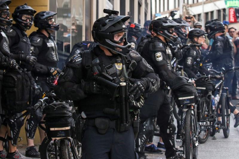 A police officer reloads after firing a nonlethal weapon into a crowd during anti-capitalist protests following May Day marches in Seattle, Washington on May 1, 2016.