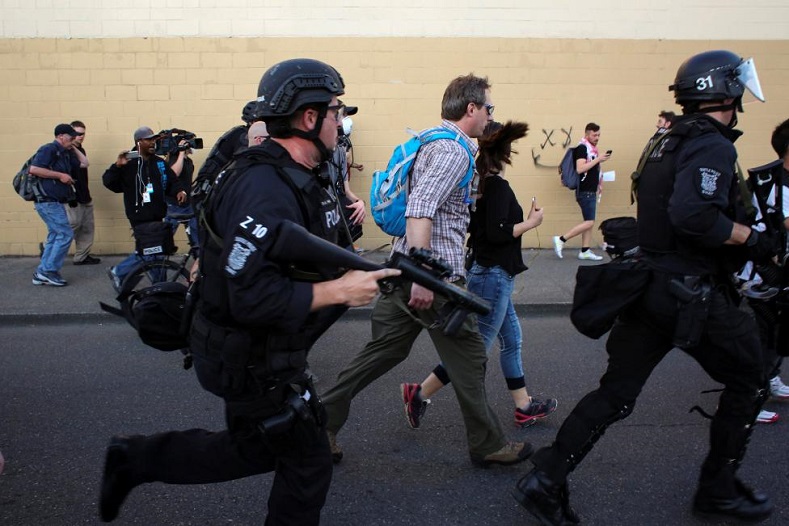 Police pursue a protester before detaining him.