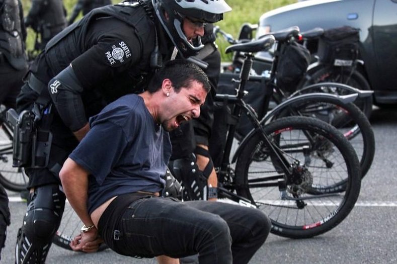 Police detain a protester during anti-capitalist protests following May Day marches.