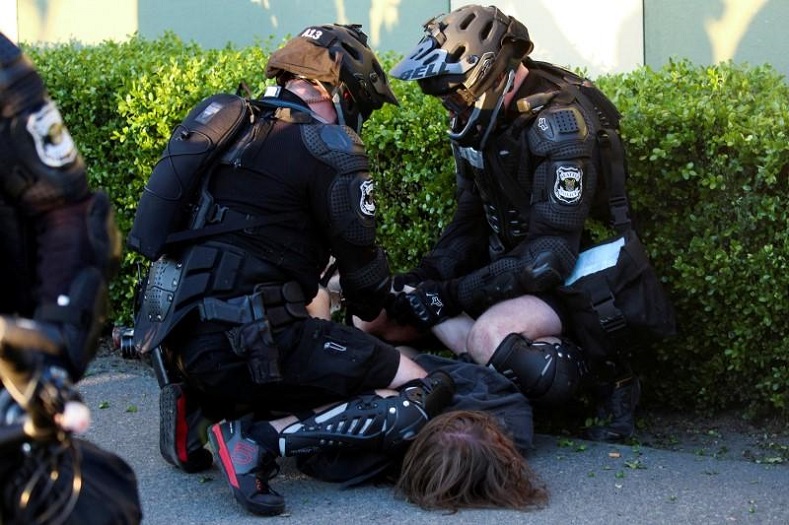 Police brutally detain a protester. 