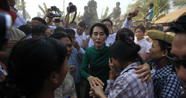 Myanmar pro-democracy Leader Aung San Suu Kyi comforts a woman at a village in Sarlingyi township.
