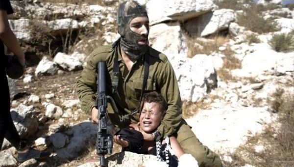 An Israeli soldier detains a Palestinian boy during a protest against Jewish settlements in the West Bank.