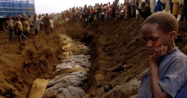 File photo of a Rwandan refugee girl staring at a mass grave where dozens of bodies have been laid to rest in 1994.