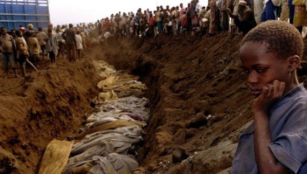 File photo of a Rwandan refugee girl staring at a mass grave where dozens of bodies have been laid to rest in 1994.