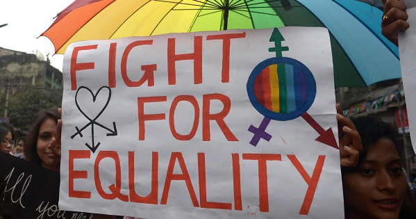 Protest sign includes transgender symbol.