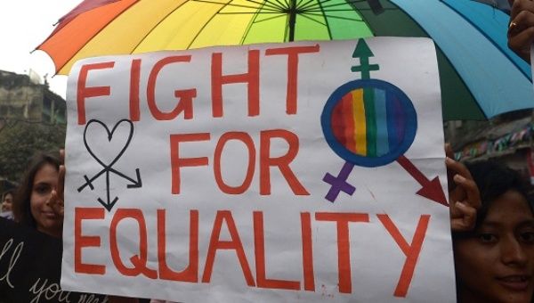 Protest sign includes transgender symbol.