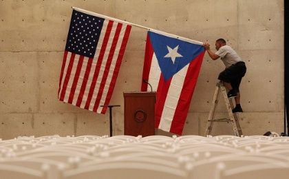 A worker takes off the U.S and Puerto Rican flag after a rally of U.S. Democratic presidential candidate Bernie Sanders in San Juan.