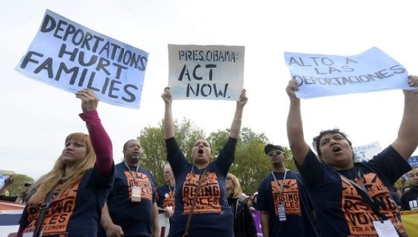 Protesters demand President Obama to stop immigration raids.