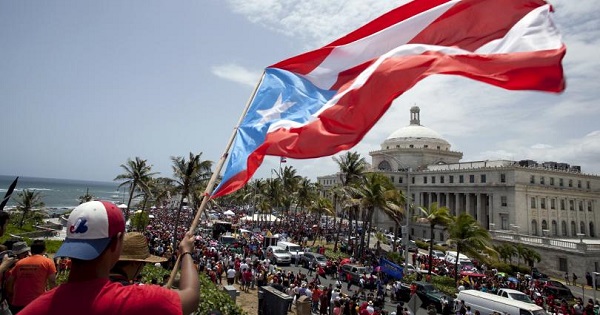 A man waves a Puerto Rico flag in San Juan as demonstrators protest austerity measures imposed because of the U.S. territory's debt crisis, May 13, 2015.