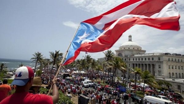 A man waves a Puerto Rico flag in San Juan as demonstrators protest austerity measures imposed because of the U.S. territory's debt crisis, May 13, 2015.