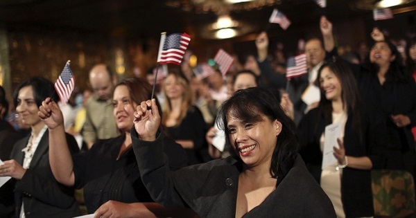 Immigrants wave flags following a US Citizenship and Immigration Services ceremony in California.