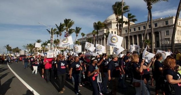 Members of labor unions march past the capitol building during a protest in San Juan, Puerto Rico.