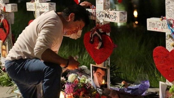 Jose Louis Morales cries at his brother Edward Sotomayor Jr.'s cross that is part of a memorial for the victims of the Orlando shooting, June 20, 2016.