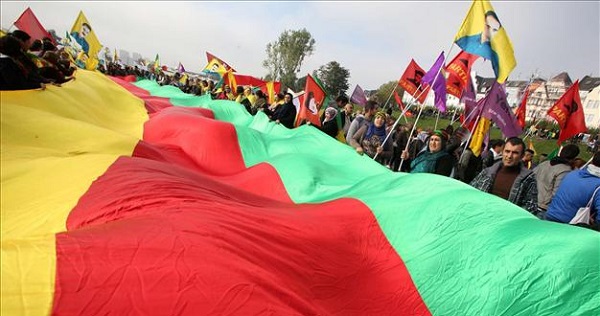 Pro-kurdish demonstrators hold a giant flag as they gather on Oct. 11 in Düsseldorf during a rally in solidarity with Kurds.