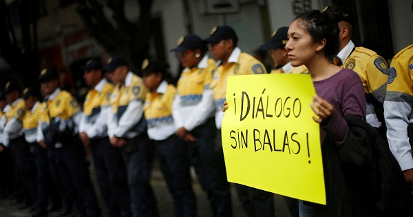 An activist holds a sign that reads 