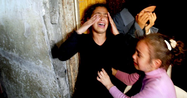 Two girls cry after their sister Mamdoh Abaid was killed in an Israeli airstrike.