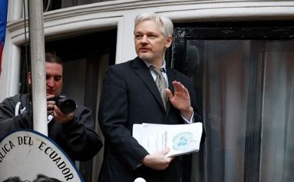 WikiLeaks founder Julian Assange holds a copy of a U.N. ruling as he makes a speech from the balcony of the Ecuadorian Embassy, February 5, 2016. 