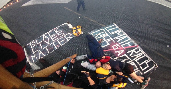 Black Lives Matter UK lock themselves together on a London City Airport runway.