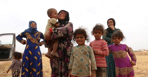 A family that fled from Hama stand in a field in southern rural Manbij where Syria Democratic Forces (SDF) have taken control, in Aleppo Governorate, Syria June 15, 2016.