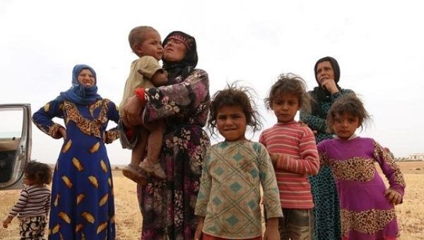 A family that fled from Hama stand in a field in southern rural Manbij where Syria Democratic Forces (SDF) have taken control, in Aleppo Governorate, Syria June 15, 2016. 