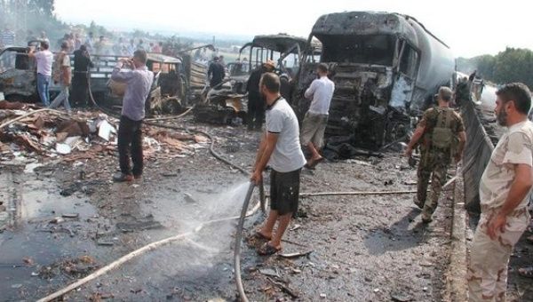 Syrian army soldiers and civilians inspect the site of two explosions in Tartous.